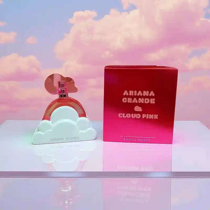 Ariana Grande Cloud Pink 100ml Eau de Parfum for women. Iconic pink cloud-shaped bottle with box on reflective surface.