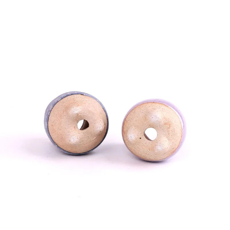 Set of mini ceramic succulent pots showing bottoms, light beige with dark blue rims