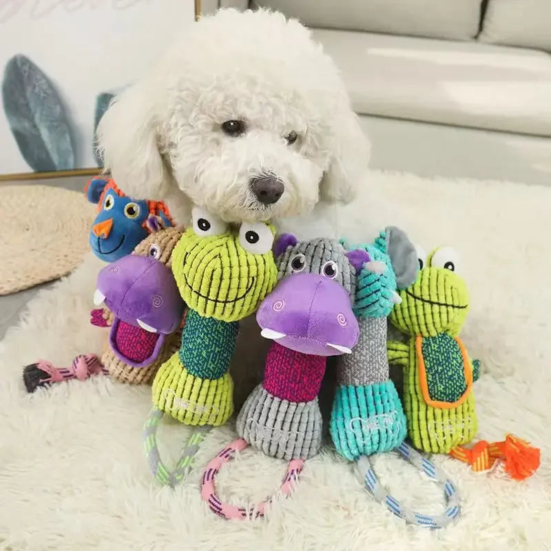 White dog with colorful plush cartoon animal squeaky rope toys for teeth cleaning and interactive pet play.