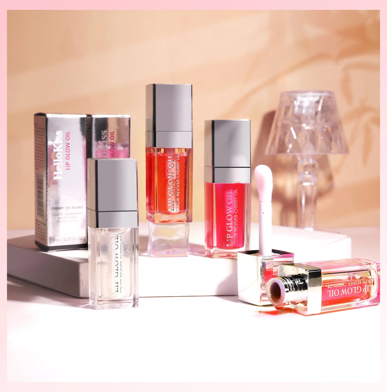 Set of moisturizing crystal jelly lip glow oils in various tinted shades with glossy, plumping texture and applicator.