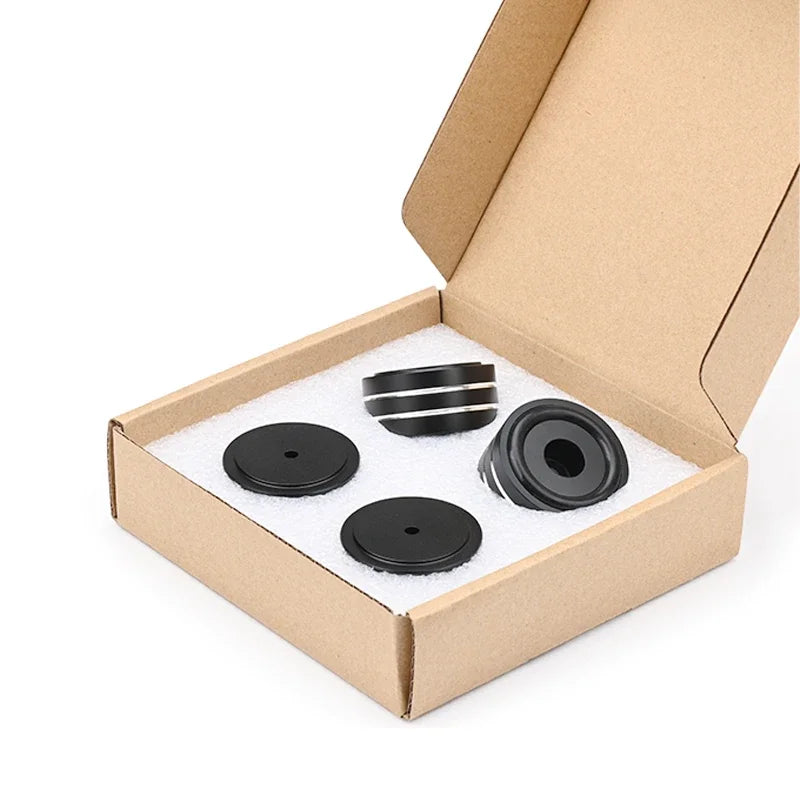 Speaker isolation pad set in an open box with black caps and silver metal rings