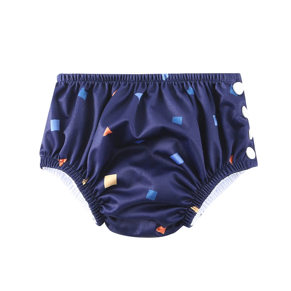 Reusable baby swim diaper in navy blue with geometric shapes and side snap buttons for adjustable fit.