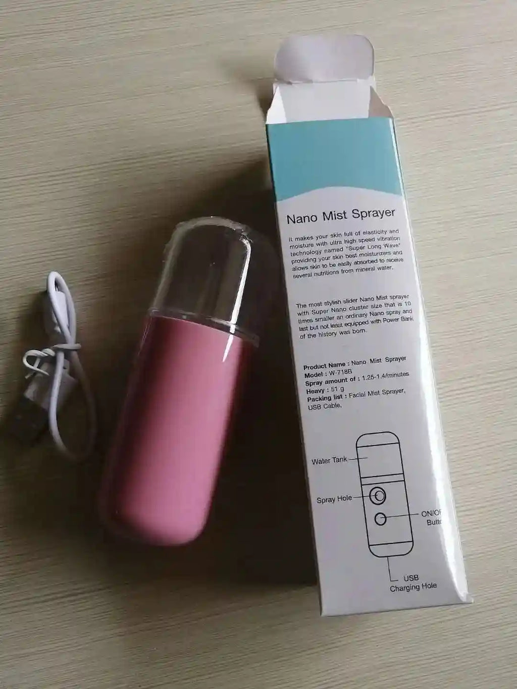 Pink portable nano facial mister sprayer with USB charging cable and packaging box for skin hydration and lashes.