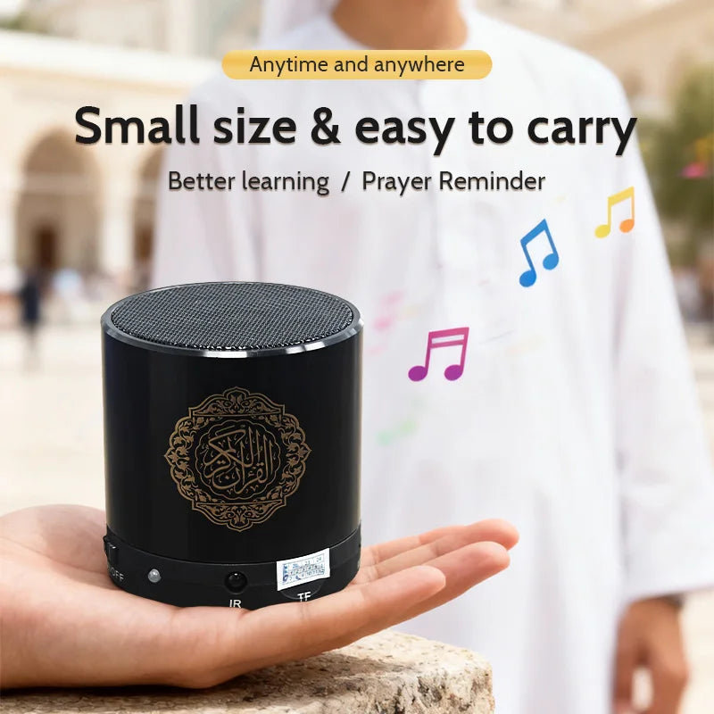 Black cylindrical Quran speaker held in hand with Arabic emblem and gray speaker grille