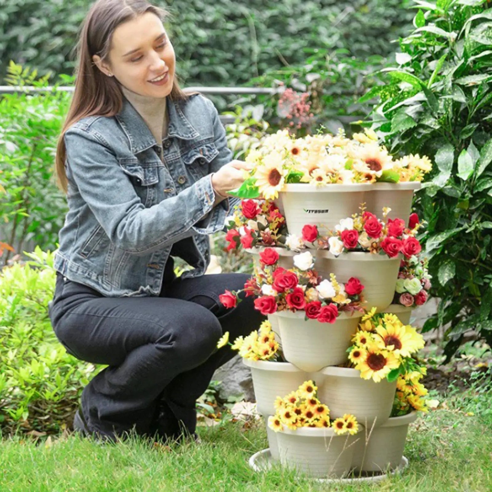 White stackable butterfly planter tower with tiered pots outdoors beside garden plants