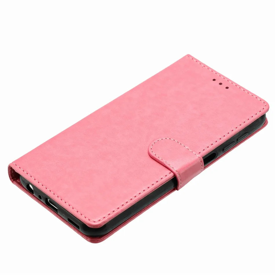 Pink leather wallet phone case with a magnetic strap closure and black inner protective shell.