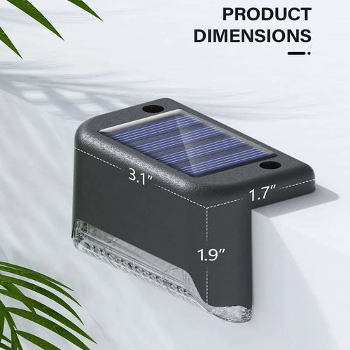 Black solar deck step light with clear lens and top solar panel, compact size.