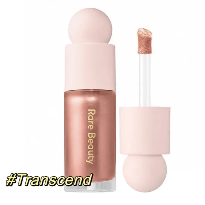 Shimmery bronze Rare Beauty liquid highlighter with applicator wand for lips and cheeks. Long-lasting glowing makeup.