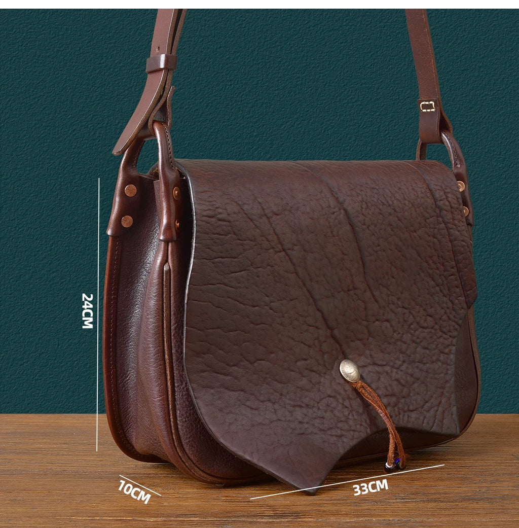Vintage handmade brown cowhide leather messenger bag with unique leaf-shaped flap and metallic stud closure.