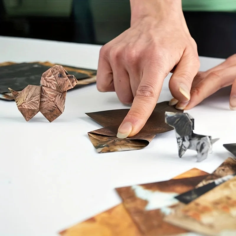 Hands folding cute origami paper dog figures. Handmade craft kit, perfect gift for pet lovers and unique home decor.