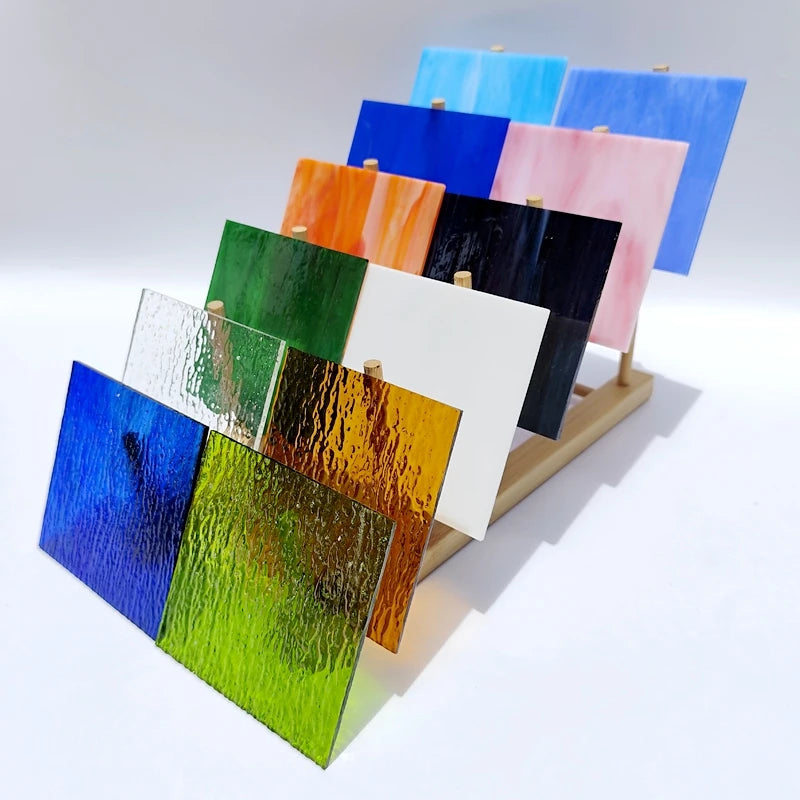 Set of 12 textured transparent stained glass mosaic tiles on display, assorted colors