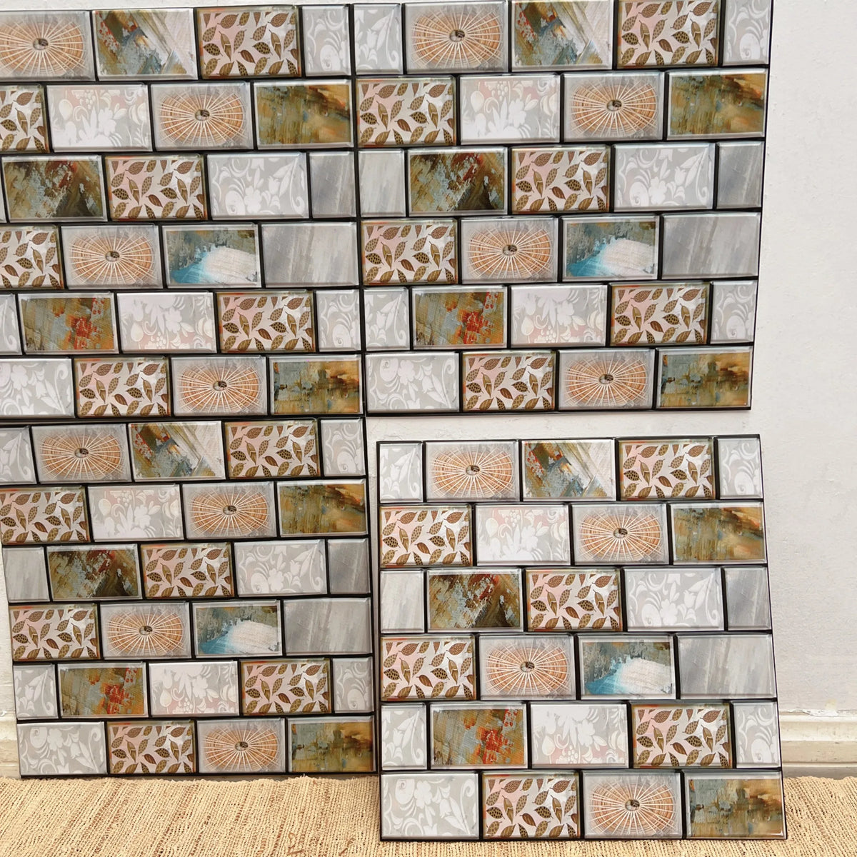 Marble-look peel-and-stick backsplash tiles with gray, beige, and floral mosaic grid