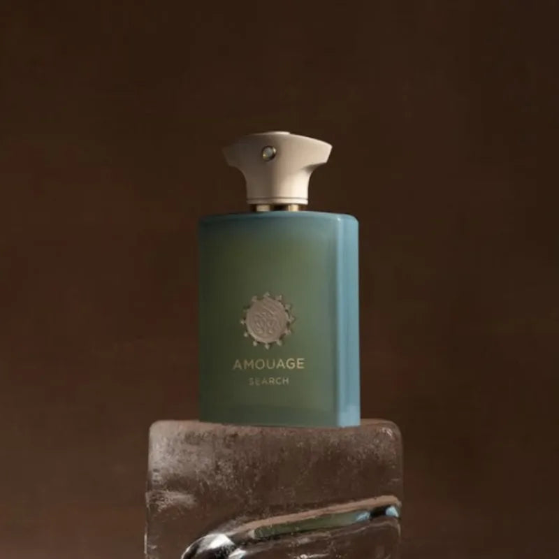 Amouage Search Men’s EDP 100ml: A woody, citrus aromatic fragrance in a modern frosted blue bottle with a sleek cap.