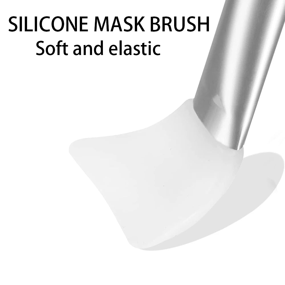 A close-up of a white, flexible silicone facial mask applicator tool with a silver handle.