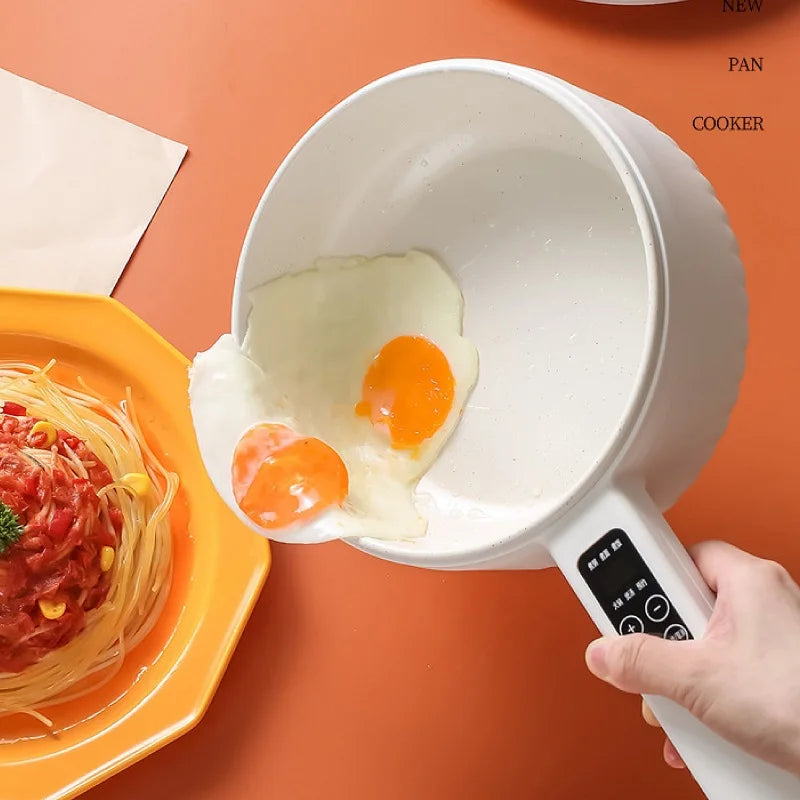 Electric cooking pot with two fried eggs and control handle held by a hand