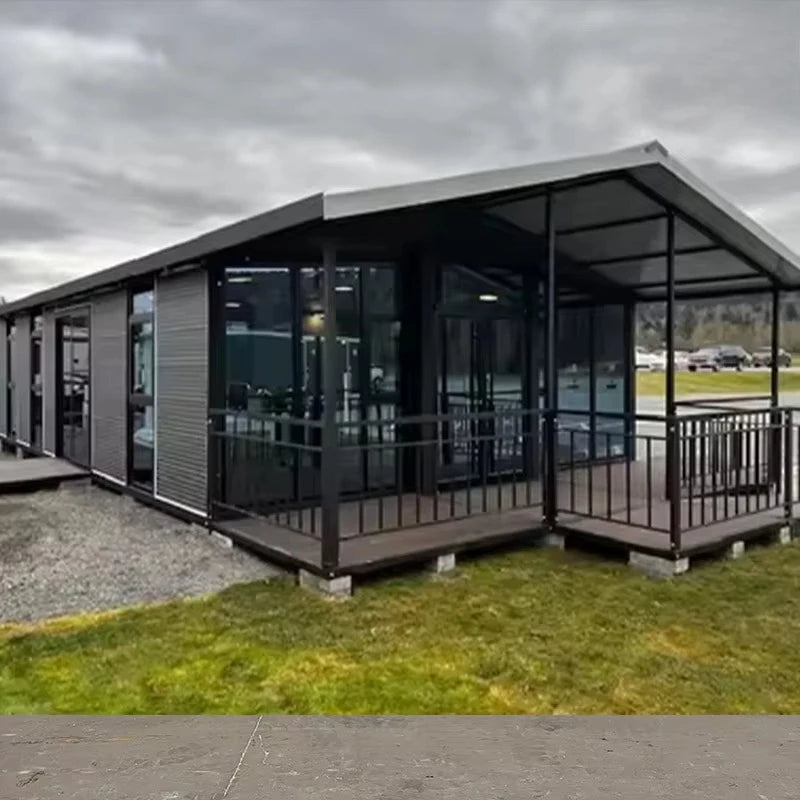 Dark-framed prefab container house with large windows and enclosed porch