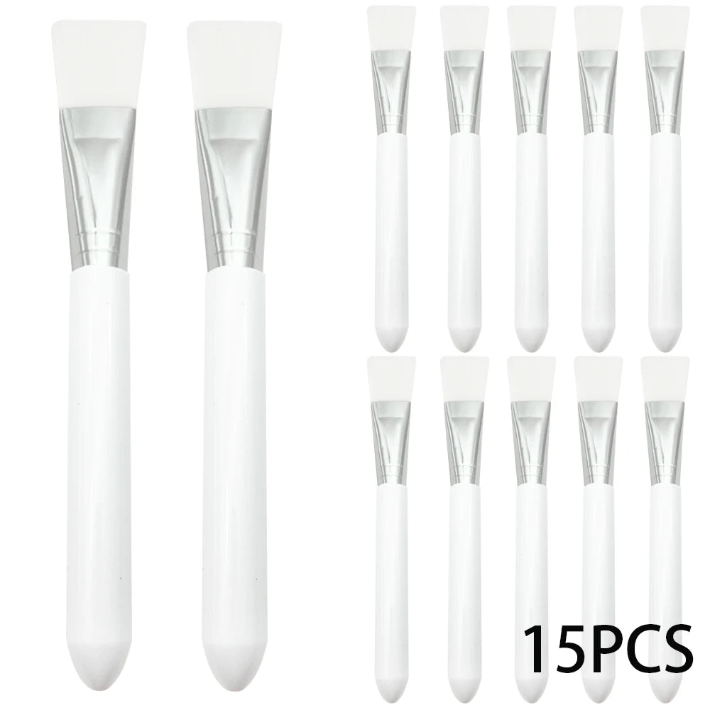 A set of 15 white silicone facial mask brushes with silver metal ferrules and smooth white plastic handles.