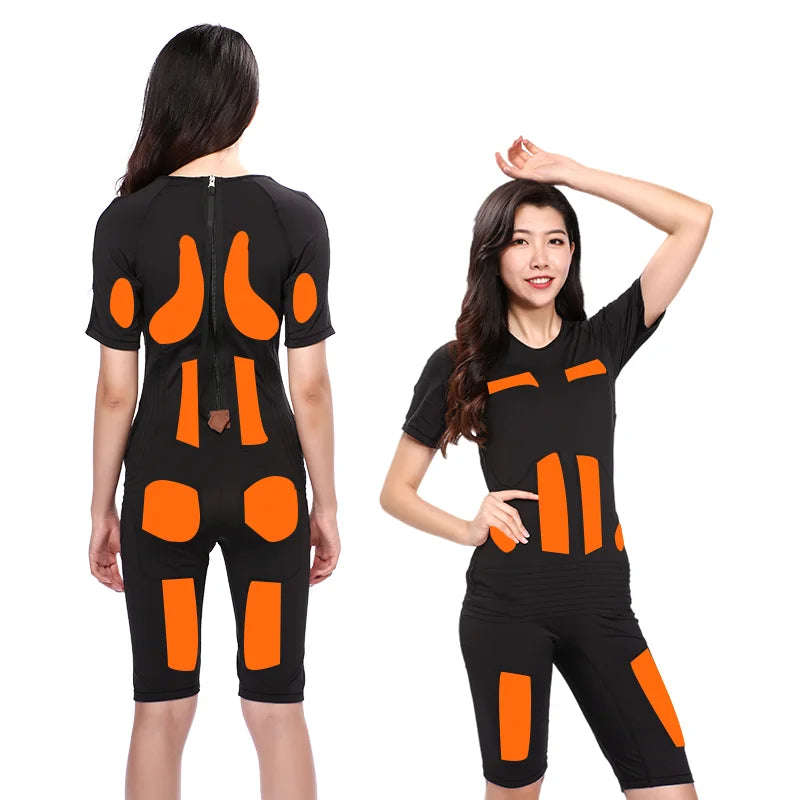 Woman wearing a black wireless EMS fitness training suit with orange muscle stimulation pads for gym workout.