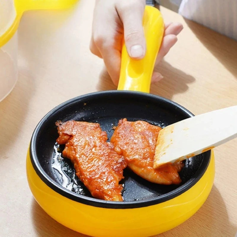 Yellow non-stick electric egg cooker on table, spatula serving cooked slices in pan.