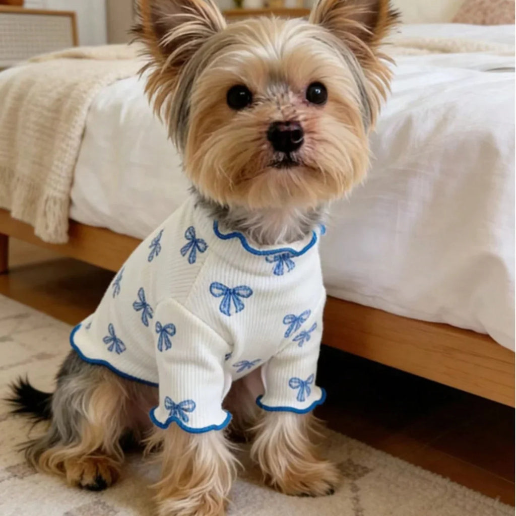 Cute small dog wearing a breathable, high-elasticity white knit shirt with blue bow ties for comfortable pet style.