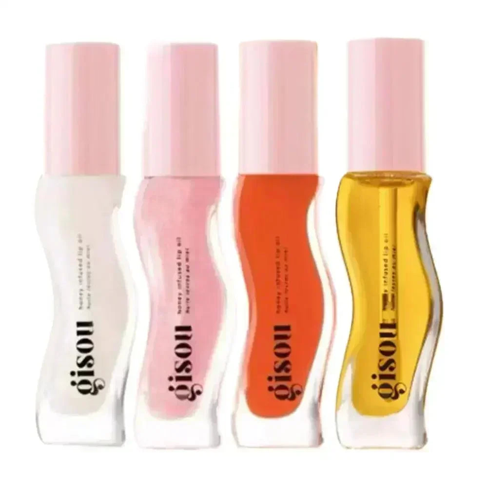 Four Gisou honey-infused liquid lip oil bottles in clear, pink, orange, and gold, providing a glossy, moisturizing finish.