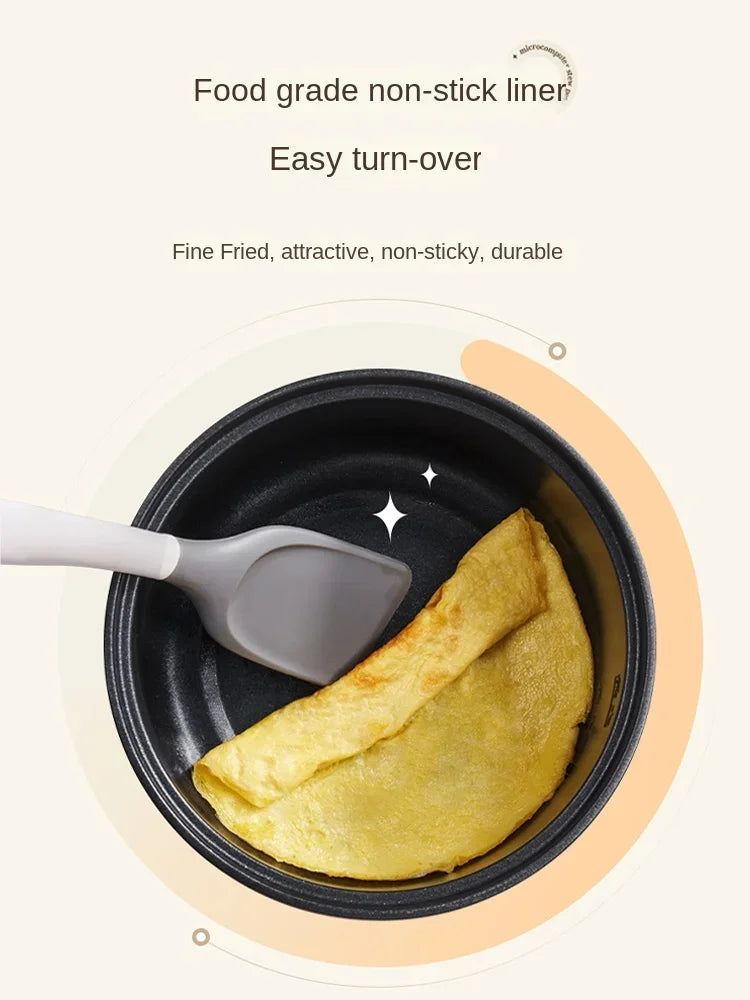 Non-stick inner cooking pot with spatula and folded omelet inside electric cooker