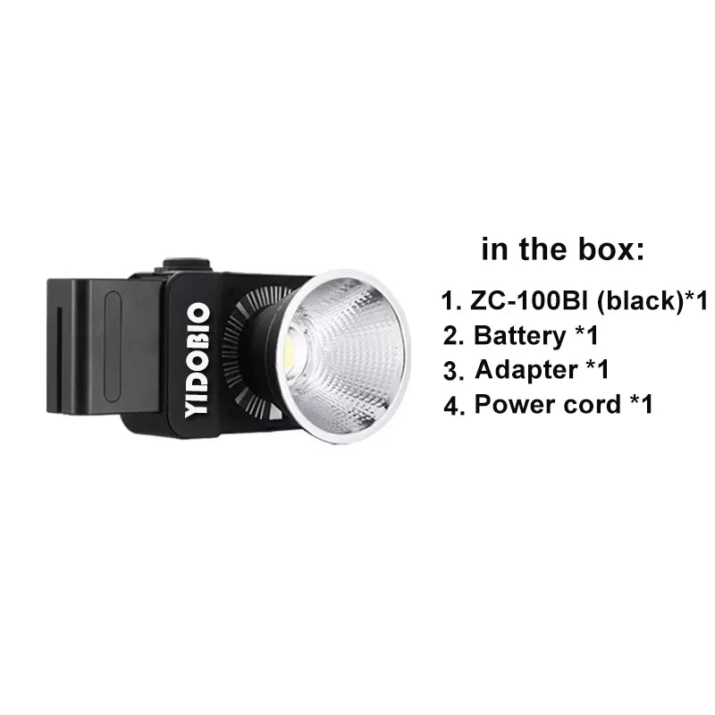 Black ZC-100BI portable LED video light with a silver reflector cup, including battery, power adapter, and cord.