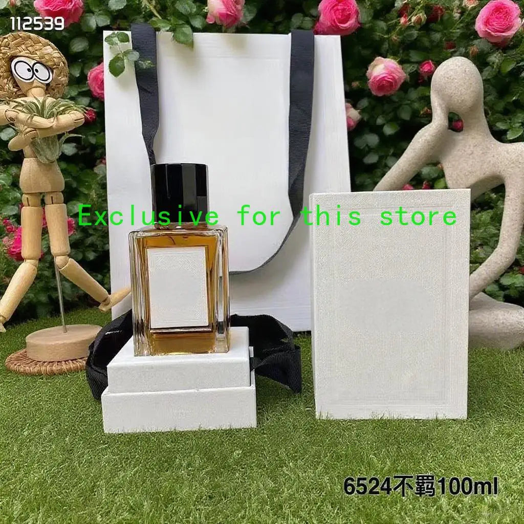 100ml amber perfume in a square glass bottle with a black cap, standing on a white display base with a matching box.