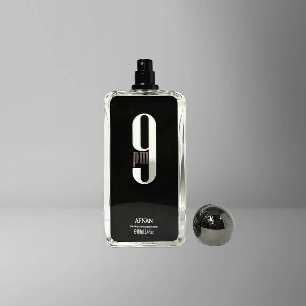 Afnan 9 PM perfume bottle with a tall rectangular clear glass design, black label, large white "9", and spherical cap.