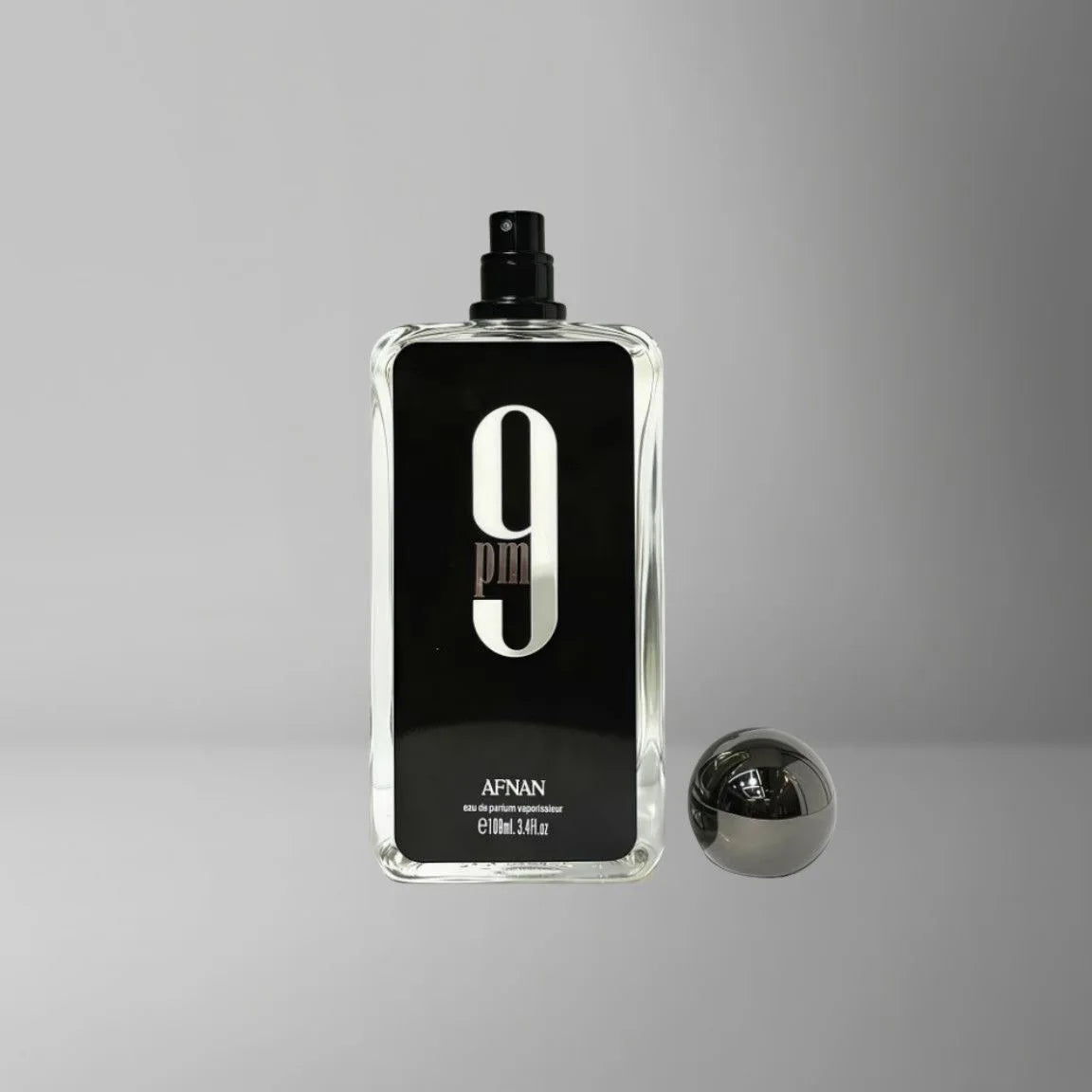 Afnan 9 PM perfume bottle with a tall rectangular clear glass design, black label, large white "9", and spherical cap.