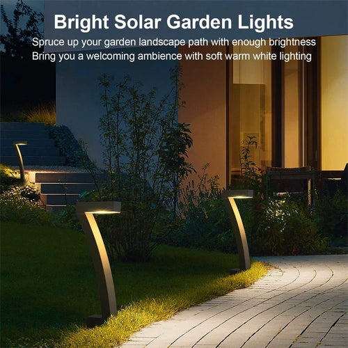 Solar garden path lights: black stake lamps casting warm light along a walkway
