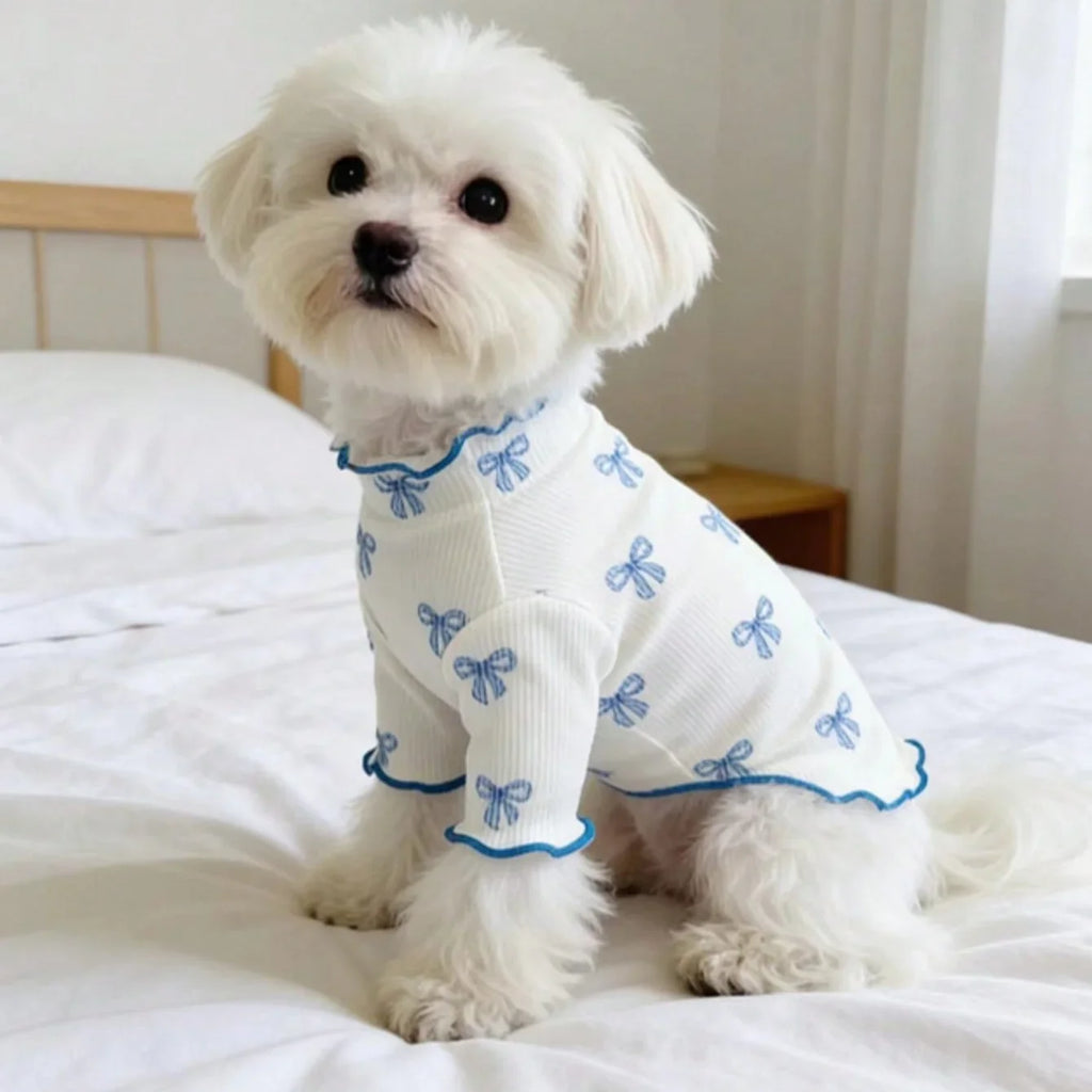 White dog wearing a breathable, stretchy knit pet shirt with a cute blue bow tie print for comfortable daily wear.