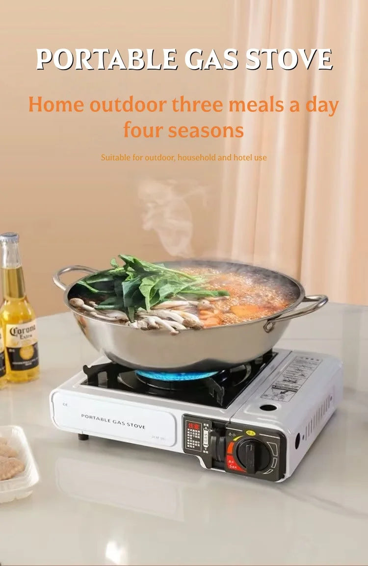 Portable gas stove with a large pan of food and blue flame on countertop