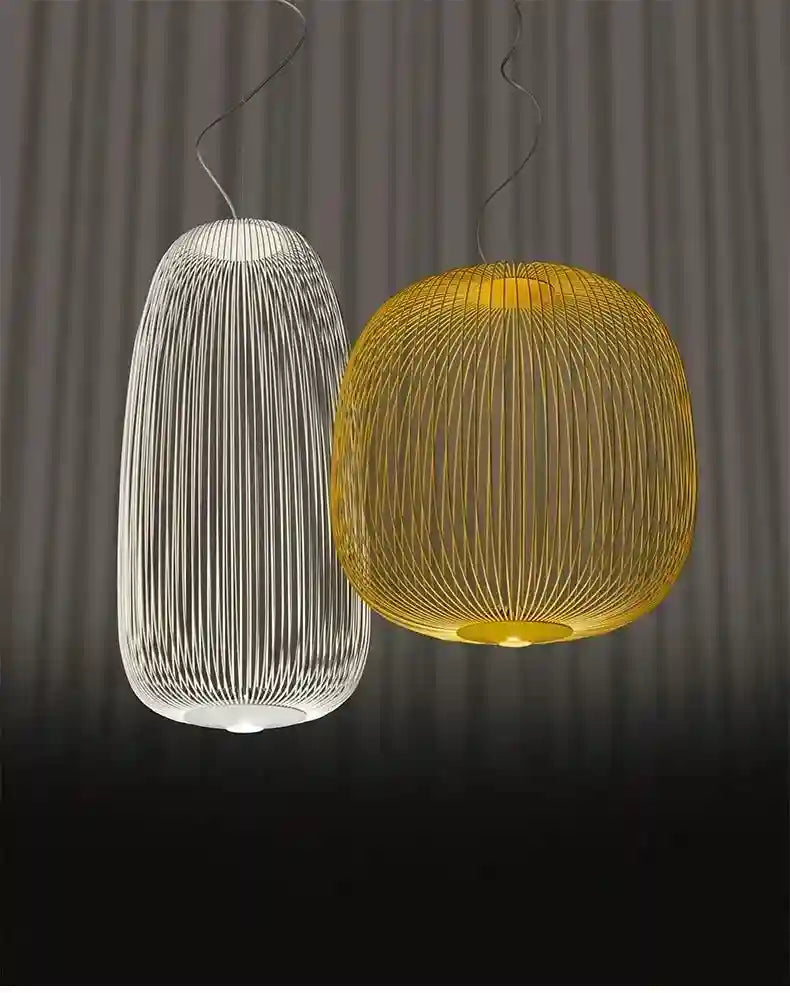 Two wire-frame pendant lights, one tall white and one round gold, suspended for overhead ambient lighting.