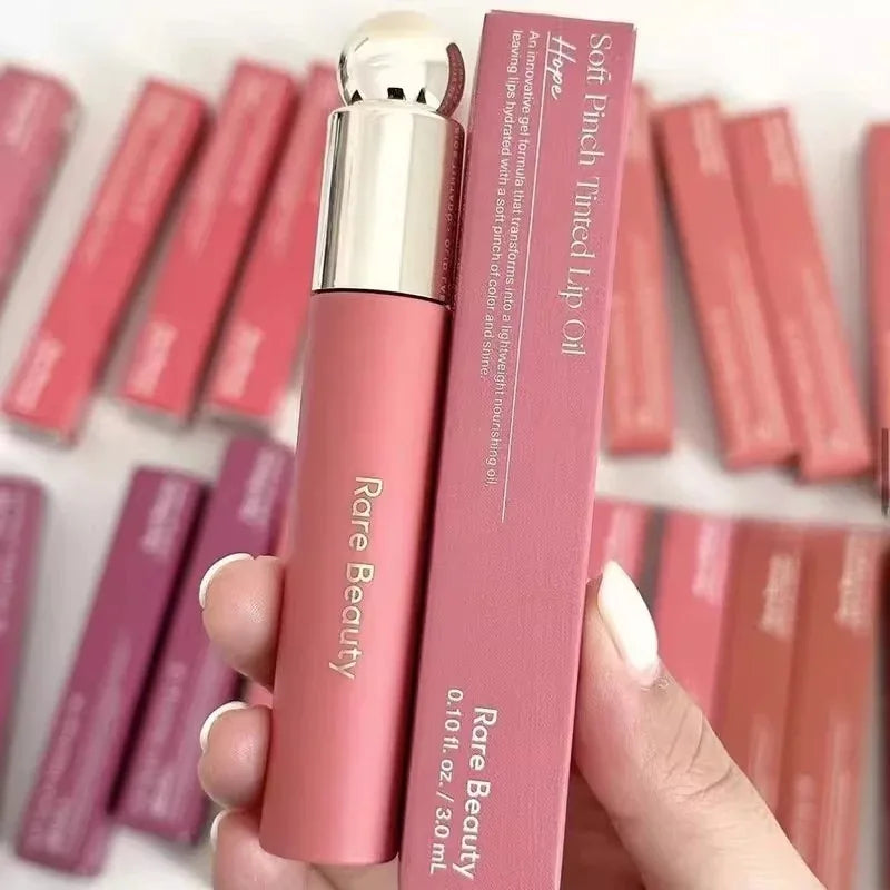 Rare Beauty Soft Pinch Tinted Lip Oil in Hope: pink matte tube, gel formula packaging, and matching boxes.