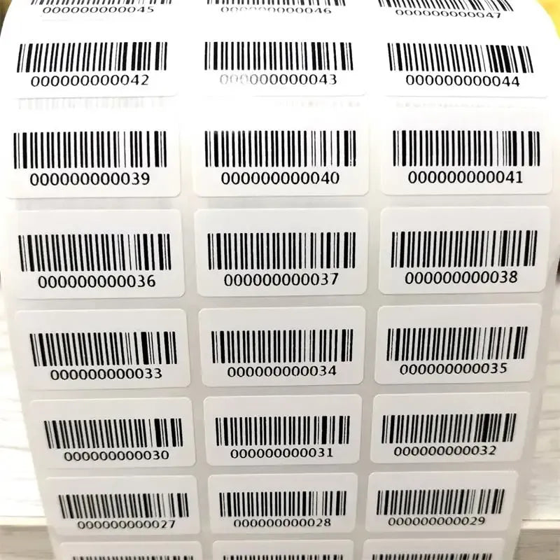 Barcode adhesive inventory number stickers on white backing, black barcodes and digits.