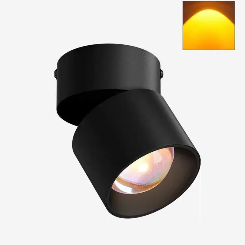 Black LED ceiling surface spotlight with angled cylindrical head and warm lit lens