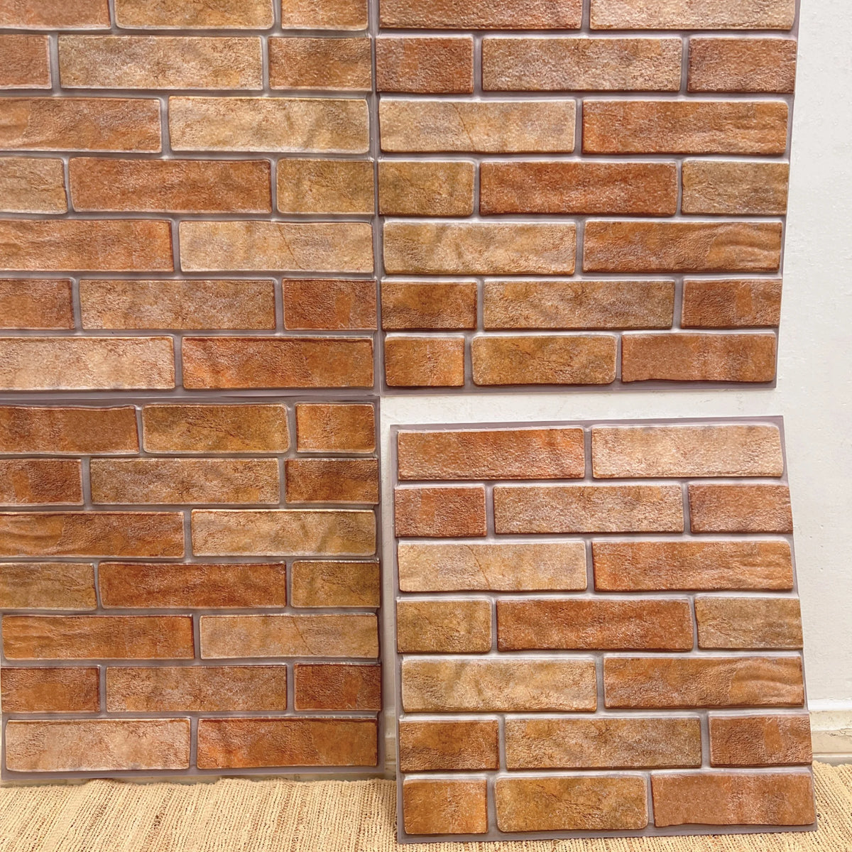 Peel-and-stick brick-look backsplash tiles in warm orange-brown, square sheet