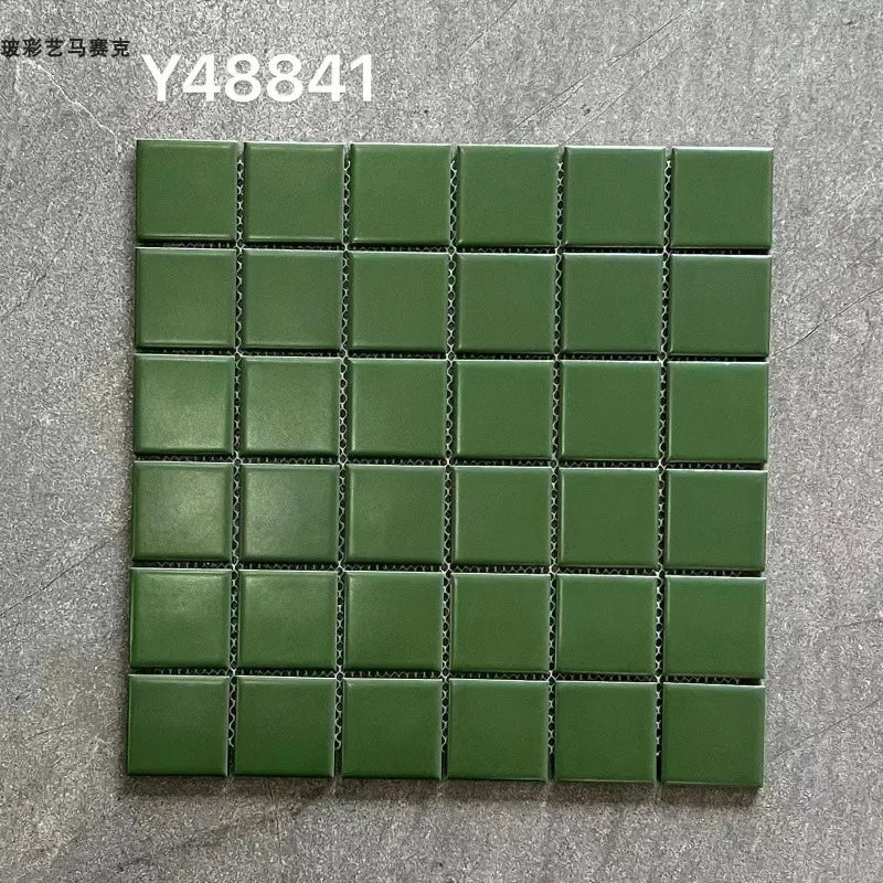 Green ceramic mosaic tile sheet with small square tiles and dark grout lines