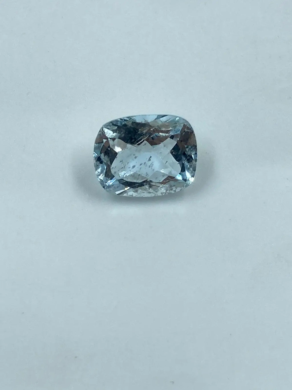 Sky-blue cushion-cut loose gemstone with faceted oval look