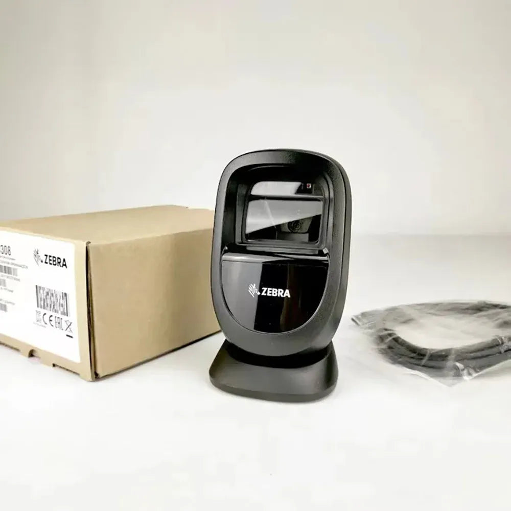 Zebra DS9308 desktop barcode scanner next to shipping box, black cradle