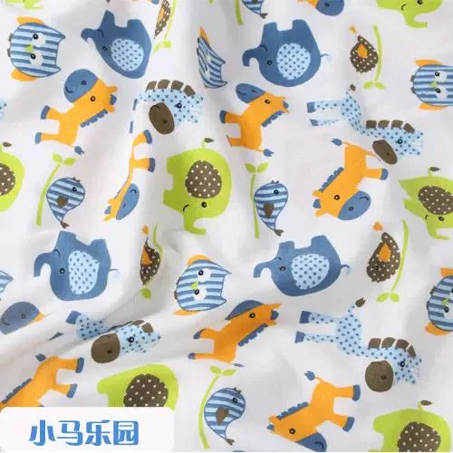Tidesmit white organic knit fabric with colorful cartoon animal print including blue elephants, yellow horses, and owls.