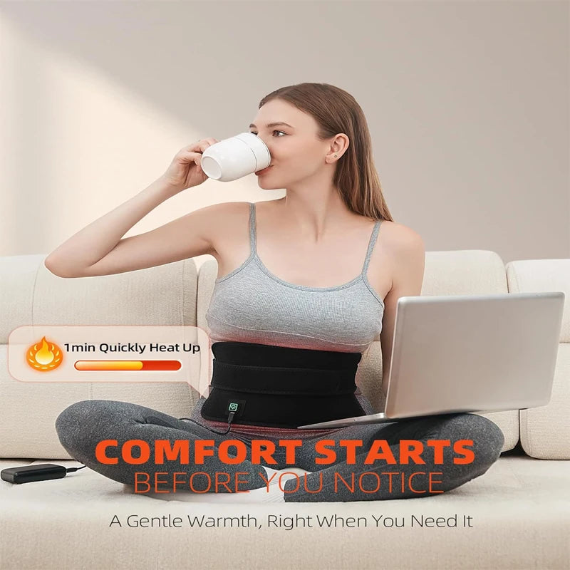 Woman wearing a black portable red light therapy belt on her waist for back pain relief while using a laptop.