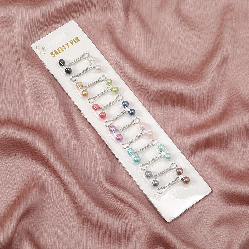 Pack of 12 silver-tone Tidesmit hijab safety pins with multicolor faux pearl bead ends on a white display card.