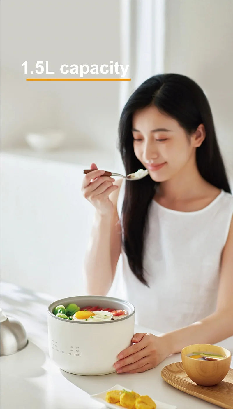 Smart white 1.5L mini rice cooker being used to drink soup with a spoon