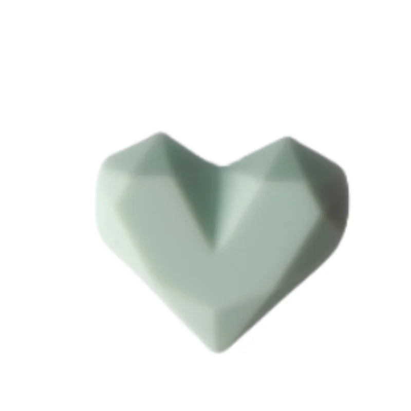 Light green silicone heart dust plug for Tamagotchi Uni, durable protective cover for electronic pet charging ports.