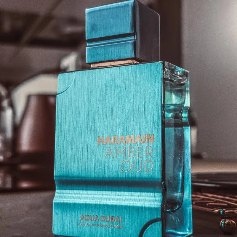 Haramain Amber Oud Aqua Dubai unisex Extrait de Parfum, metallic teal square bottle, amber, oud, floral scent for all.