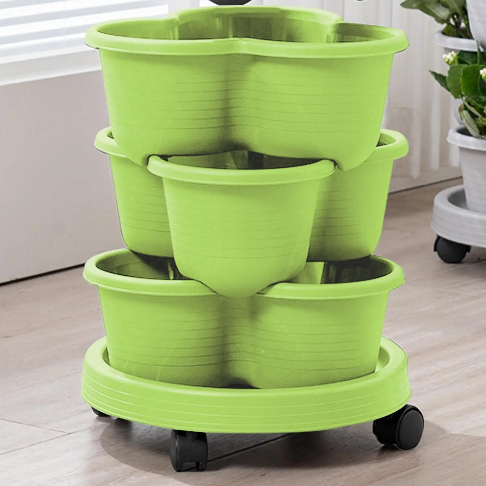 Light green stackable tiered planter tower with three pots on rolling wheels base.