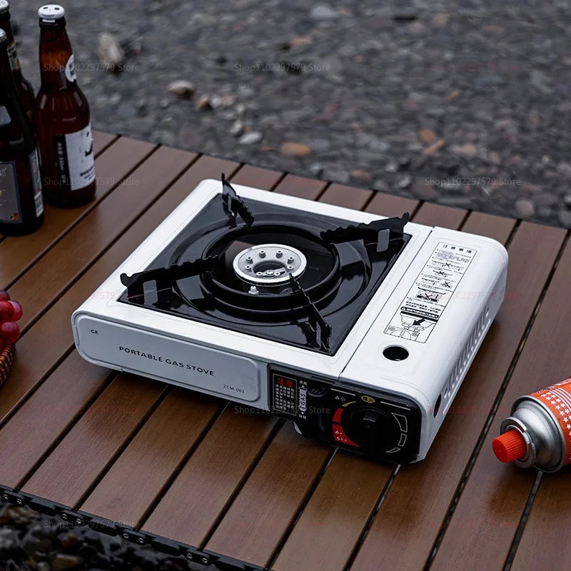 Portable gas stove on an outdoor table with control knob and ignition area