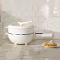 Electric cooking pot with lid on white base, standalone countertop view